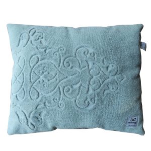 Cama retangular com atoalhado verde e motivos decorativos em cima e ganga escura no verso